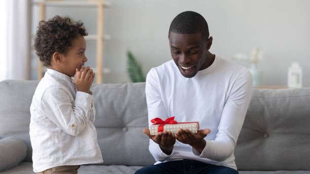 istock Shocked happy african american man looking at gift from son. 1208979608