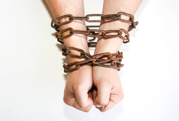 istock Hands in old rusty chains. Man in the trap. Slave concept. 1208983106