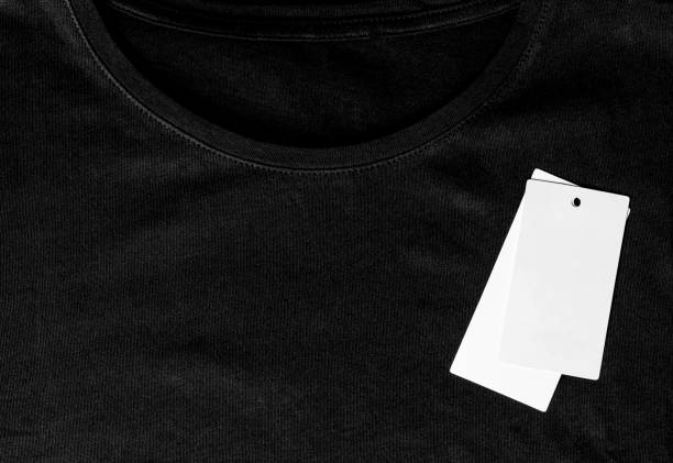 istock Black t-shirt close-up and white clean label top view 1208983324