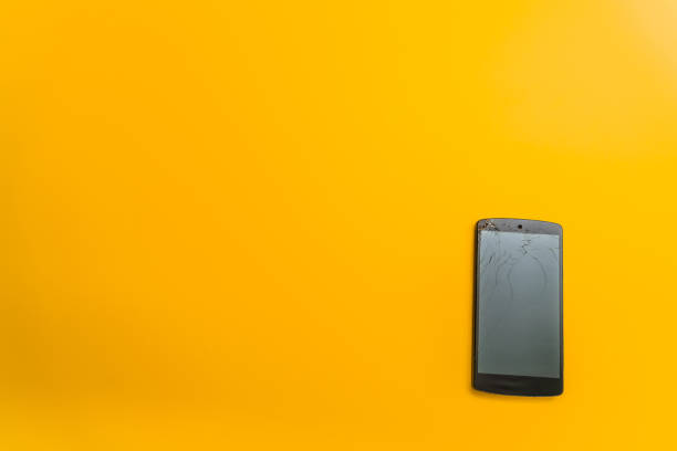 istock Mobile phone with damaged screen on yellow background 1208986273
