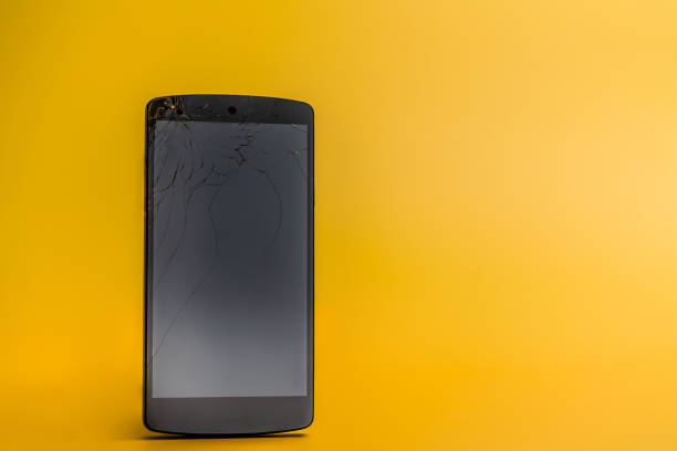 istock Smartphone with cracked screen on yellow background 1208986293