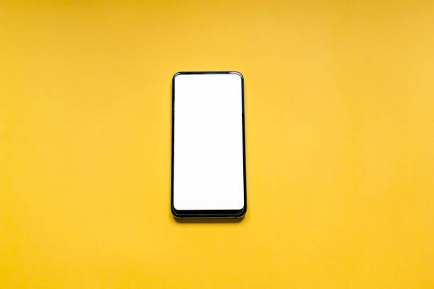 istock smartphone with white screen in vertical position isolated on a yellow background. Technology concept 1208986499