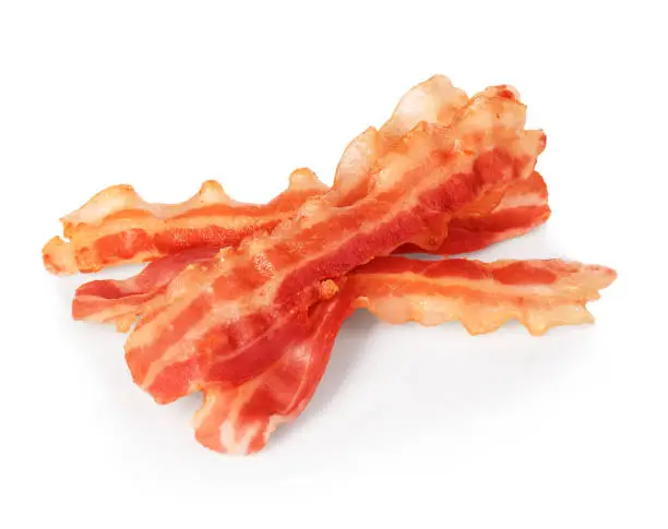 Strips of fried bacon closeup isolated on a white background. Classic american style.
