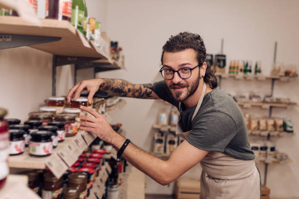istock Young, satisfied man working at his grocery store 1208991629
