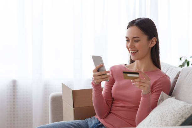 istock Woman holding a credit card and using smartphone 1208993993