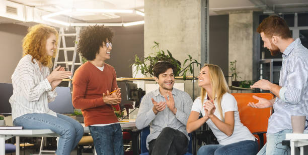 istock Young creative team cheering new comer girl in office 1208995340