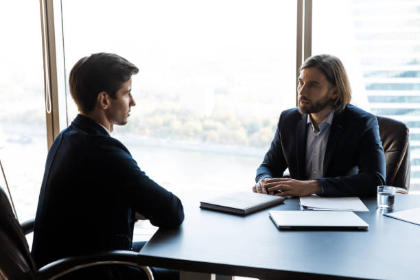 istock Serious businessman talking with mentor coach lead in office. 1208998451