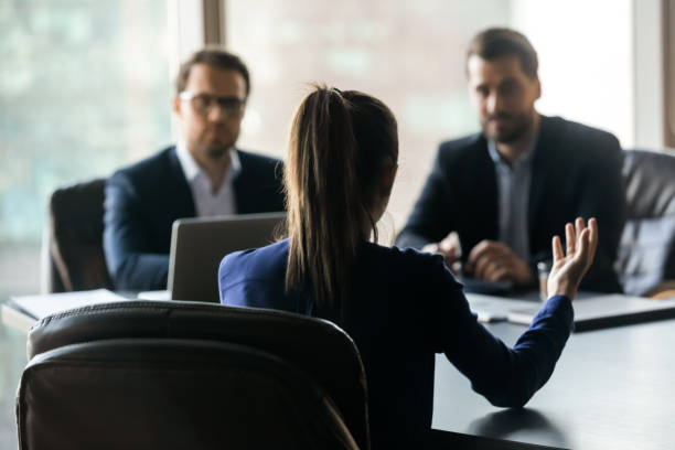 istock Hiring attractive woman applicant back sitting in front two HR. 1208998519