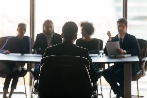istock Handsome man applicant back sitting in front HR diverse businessmen. 1208998527