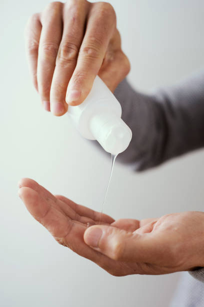 istock man disinfecting his hands with hand sanitizer 1209000398