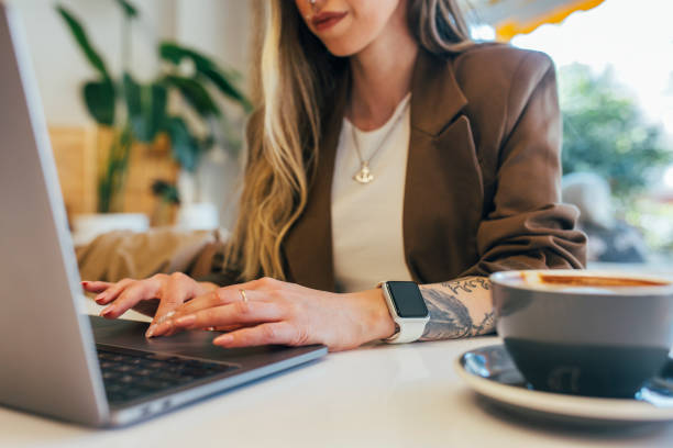 Young Freelancer Woman Working at Cafe Young Freelancer Woman Working at Cafe smart watch business stock pictures, royalty-free photos & images
