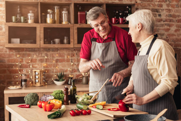 istock Happy senior couple enjoying preparing dinner together, cooking in kitchen 1209003889