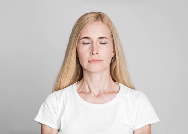 istock Beautiful middle-aged woman posing with closed eyes 1209004057