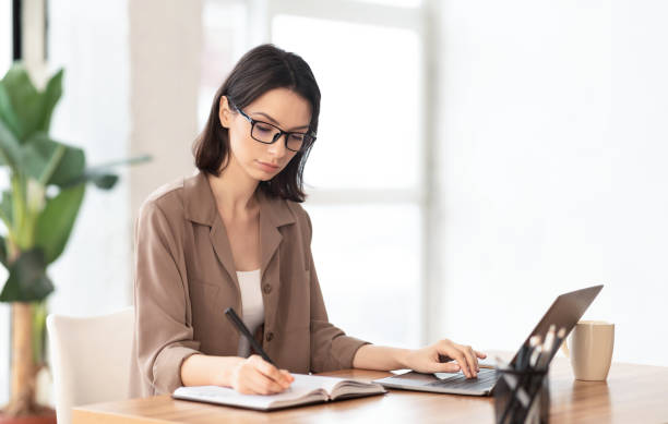 istock Portrait of concentrated manager writing in notebook 1209006243