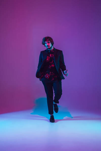 istock Young caucasian musician dancing in neon light 1209006413