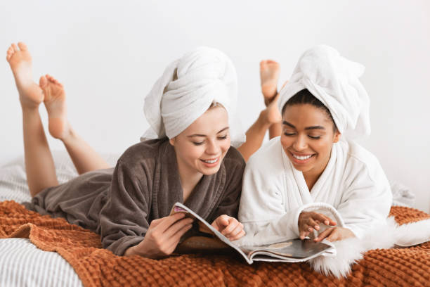 istock Carefree multiracial ladies reading magazine while having spa procedures 1209006731
