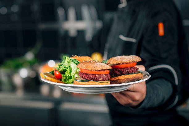 Male chef holding a plate with vegan meal.