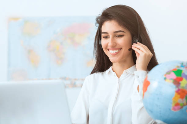 istock Happy travel agent speaking to customer in office 1209008056