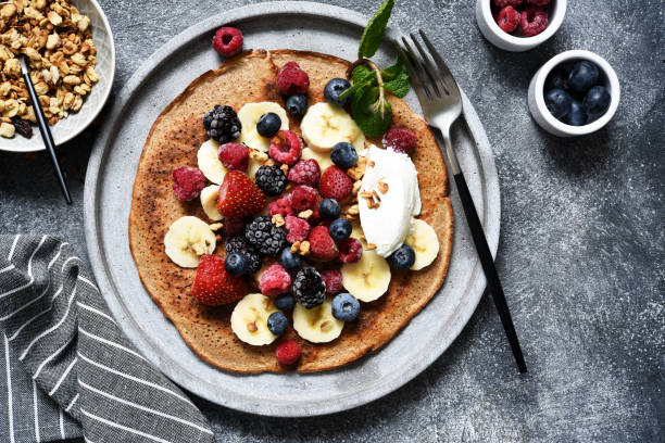 istock Crepe with berries and yogurt for breakfast. Breakfast on the kitchen table top view. 1209008425