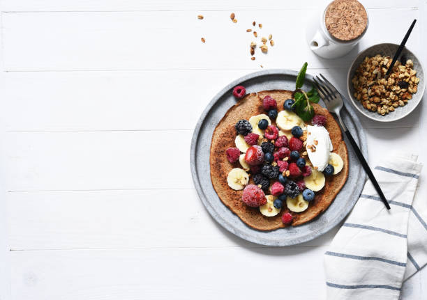 Crepe with berries and yogurt for breakfast. Breakfast on the kitchen table top view.