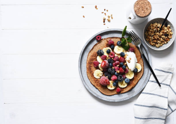 crepe with berries and yogurt for breakfast. breakfast on the kitchen table top view. - strawberry blueberry raspberry glass imagens e fotografias de stock
