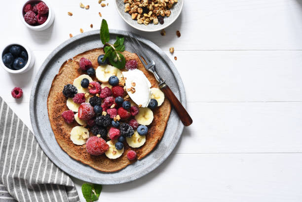 istock Crepe with berries and yogurt for breakfast. Breakfast on the kitchen table top view. 1209008504