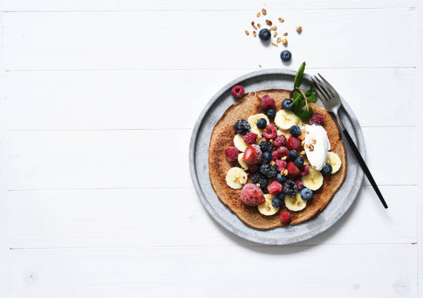 crepe with berries and yogurt for breakfast. breakfast on the kitchen table top view. - strawberry blueberry raspberry glass imagens e fotografias de stock
