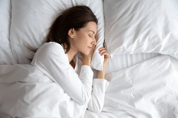 Photo of Serene beautiful woman sleeping with hand under cheek on pillow