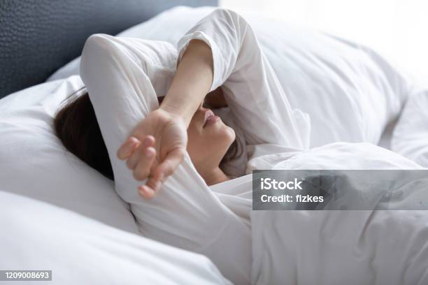 Sleepless Young Woman Suffering From Insomnia Covering Eyes With Hands Stock Photo - Download Image Now
