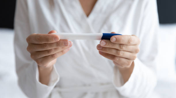 istock Close up young woman holding pregnancy test, checking result 1209008720