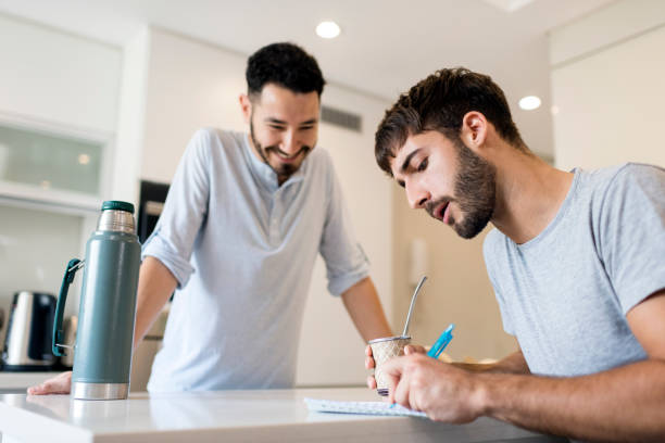 istock Couple writing a shopping list at the kitchen counter 1209009370