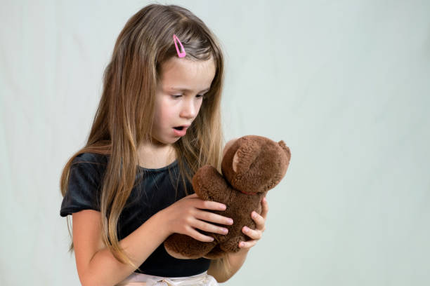 istock Pretty child girl playing with her teddy bear toy. 1209009397