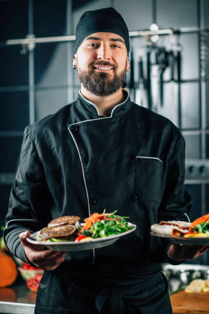 istock Smiling Chef Serving Organic Vegan Burger with Fresh Salad 1209009597