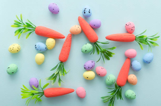 istock Closeup of decorative carrots and little easter eggs on the blue surface.Concept of easter fun and games 1209010129
