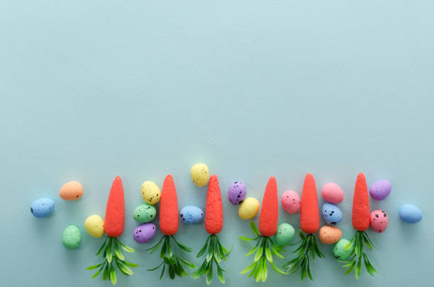 istock Top view of decorative easter quail eggs and little carrots on the bright blue background.Empty space for text 1209010236