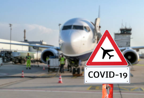 Airplane at the airport warning sign coronavirus Airplane at the airport warning sign coronavirus allegory painting photos stock pictures, royalty-free photos & images