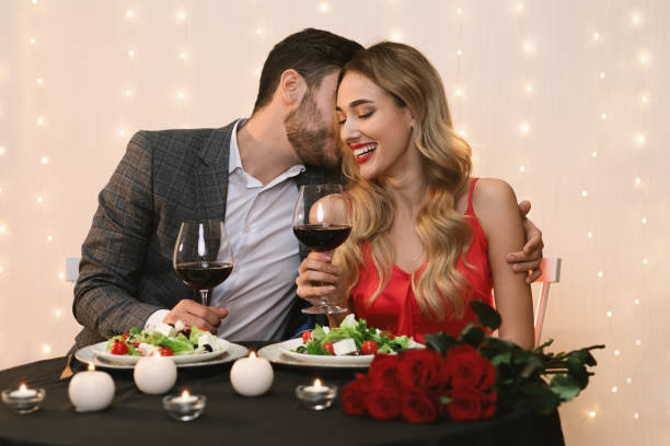 istock Young couple having romantic evening in restaurant, hugging and drinking wine 1209010568