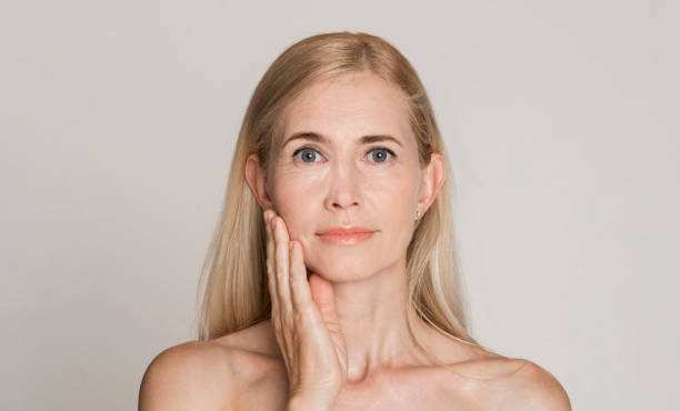 istock Beautiful caucasian middle-aged woman touching her face 1209011334