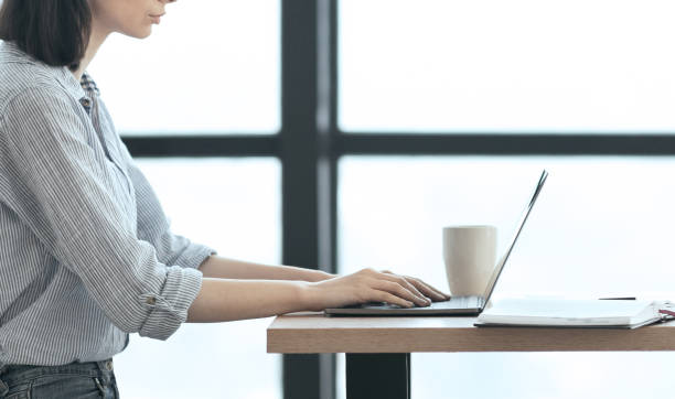 istock Unrecognizable girl working with laptop at modern office 1209011412