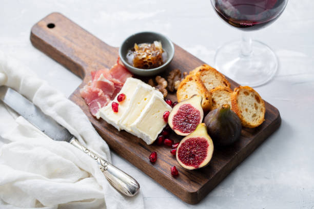 istock figs with cheese and pomegranate on wooden board and red wine on ceramic background 1209011521