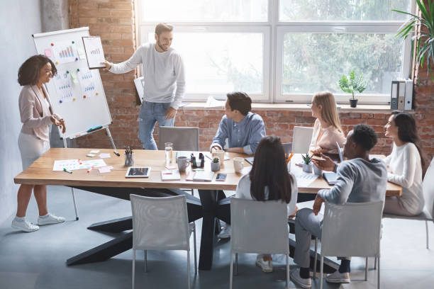 istock Business partners making presentation for young creative team 1209011597
