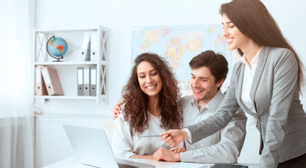 istock Offering tours. Travel agent working with happy clients 1209011727