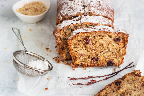 maçã picante, nozes e bolo de pão de cranberry seco decorado com açúcar em pó em um papel. - walnut bread - fotografias e filmes do acervo