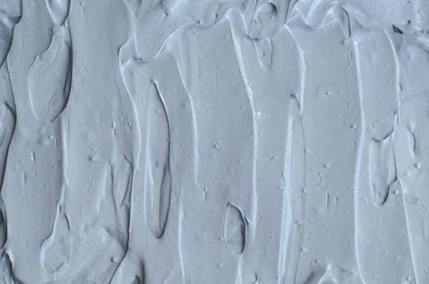 istock Gray bentonite facial clay (mask, face cream, body wrap) texture close up, selective focus. Abstract background with brush strokes. 1209011793