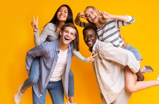 istock Two international teen couples having fun over yellow background 1209011909