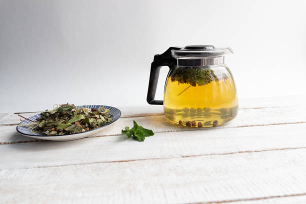 istock Glass tea pot  with brewed forest herbs  on rustic wooden background 1209013025