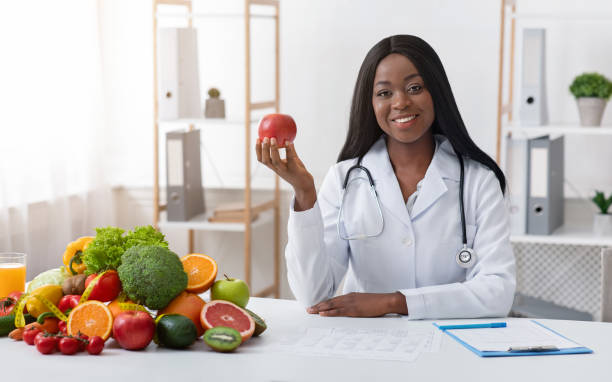 istock Beautiful doctor dietologist holding apple in her hand 1209014366