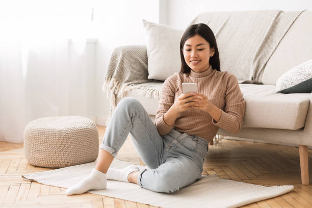 istock Modern girl checking emails on smartphone at home 1209014662