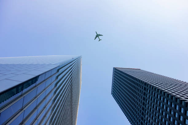 A plane flies over a commercial building