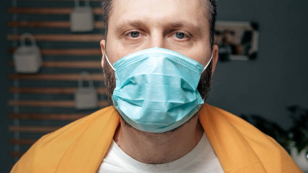 istock Man in respiratory mask. Masked attractive guy looks at camera. Cold, flu, virus, tonsillitis, acute respiratory disease, quarantine, epidemic concept 1209014986